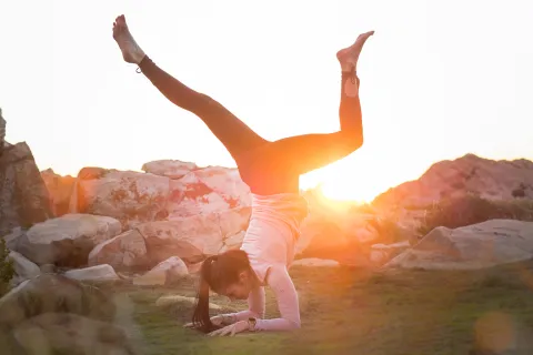 a woman doing a yoga pose in the sun